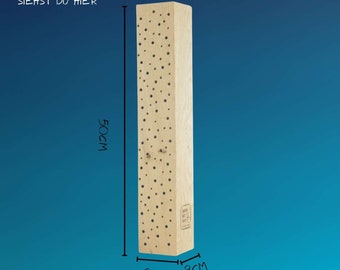 Puede incluir: Un bloque de madera marrón claro con un patrón de pequeños puntos negros. El bloque mide 50 cm de alto y 9 cm de ancho. El texto "MEINE MABE SIEHST DU HIER" está impreso en el bloque.