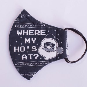 May include: A black face mask featuring a white pixelated pattern of stars and geometric shapes. The text "WHERE MY HO'S AT?" is printed in white pixelated font next to a graphic of a Santa Claus face wearing sunglasses and a moustache.