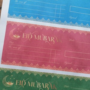 May include: Three printable gift certificate templates with a crescent moon and mosque design. The text "Eid Mubarak" is written in gold script on each template. The templates are in blue, red, and green.