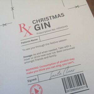 May include: A humorous Christmas-themed prescription for "Christmas Gin" with the prescription number "HOHOHO". The dosage instructions are to take the gin as needed with a mixer or neat over ice. The warning states that consumption of alcohol may make you think you can sing, but you can't. The prescription is signed by "Santa Claus" and includes a barcode.