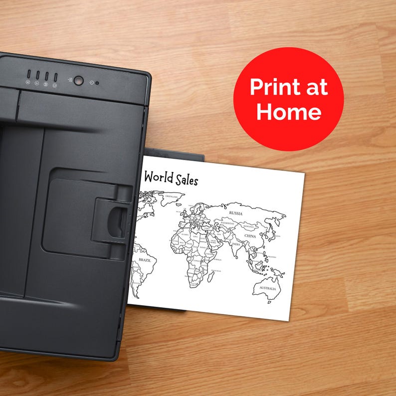 May include: A black printer sits next to a white sheet of paper featuring a black and white outline map of the world with the text World Sales. A red circular graphic with the white text Print at Home is positioned in the upper right corner.