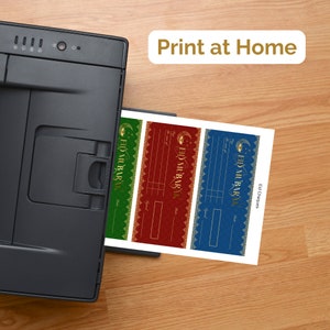 May include: A printer printing out three Eid Mubarak gift certificate templates. The templates are in green, red, and blue with gold accents. The text "Print at Home" is visible above the printer.