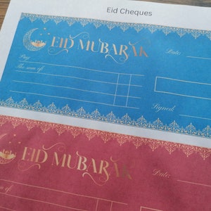 May include: Two printable Eid Mubarak gift cheque templates. The top template is blue with gold accents and the bottom template is red with gold accents. Both templates have a crescent moon and star design with the words "Eid Mubarak" in gold lettering.