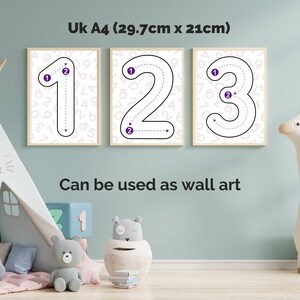 May include: Three framed posters in UK A4 (29.7cm x 21cm) size featuring the numbers 1, 2, and 3. Each number is outlined in black with purple directional circles and dashed lines indicating stroke order, set against a light background with faint numbers.