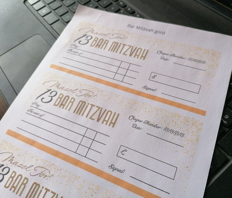 May include: A white paper sheet featuring three printed templates for Bar Mitzvah gift cheques. Each template includes the text Mazel Tov, 13 Bar Mitzvah, Pay, The sum of, Cheque Number: 18181818, Date, and Signed, with gold-colored accents and borders.