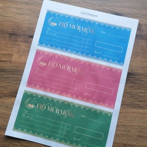 May include: Three printable Eid Mubarak gift certificate templates. The templates are blue, pink, and green with gold accents and a crescent moon design. Each template has a space to write the amount of the gift, the date, and a signature.