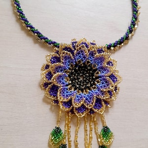 Purple and gold beaded necklace, huichol flower pendant