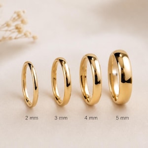 Op de afbeelding: Vier goudkleurige ringen van verschillende breedtes worden getoond. De ringen zijn 2 mm, 3 mm, 4 mm en 5 mm breed. De ringen hebben een glad, glanzend oppervlak. De ringen zijn waarschijnlijk sieraden of trouwringen.