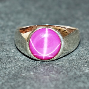 Peut inclure: Une bague en argent avec une pierre précieuse en rubis étoilé rose.