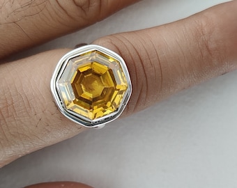 May include: A silver ring with a large, octagonal, yellow gemstone.