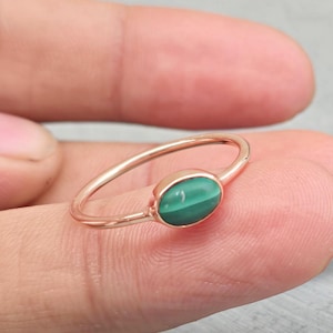 Könnte beinhalten: Ein Ring aus Roségold mit einem ovalen, grünen Edelstein.