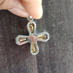 May include: Silver cross pendant with four clear yellow faceted stones.