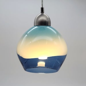 May include: A blue and white glass pendant light with a silver metal canopy. The glass shade has a gradient from light blue to white.