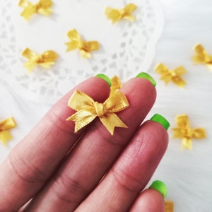 Winzige Goldschleifen (25 / 50 Stück), Mini-Satinschleifen, Goldbandschleifen, Kartenherstellungschleifen, Einladungschleifen, Puppenherstellung, Hutmacherwaren, Baby-Duschezubehör