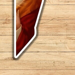 May include: A close-up of a painting of a person wearing a red and gold robe. The painting is framed in a white border.