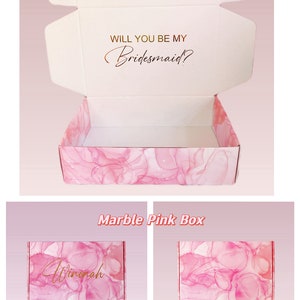 May include: A pink and white marble patterned gift box with the text "Will you be my Bridesmaid?" on the lid. The box is open and the inside is empty. The box is labeled "Marble Pink Box".