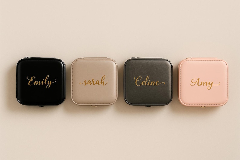 Pu&ograve; includere: Quattro portagioie quadrati con cerniera in nero, beige, grigio scuro e rosa. Ogni custodia ha un nome in oro scritto in corsivo: Emily, Sarah, Celine e Amy. Le custodie sono disposte in fila su uno sfondo neutro.