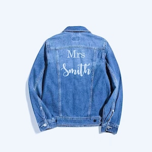 May include: A blue denim jacket with the text "Mrs. Smith" embroidered on the back in white.