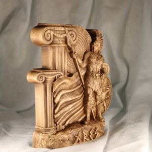 Side view of a dark wood Ares statue panel, showcasing detailed relief carving of the Greek god of war with spear and shield, classic Ionic columns, and "ARES" inscription.