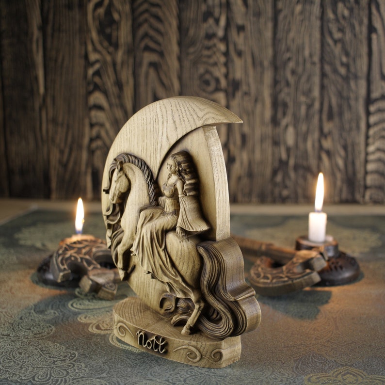 May include: Wooden sculpture of a woman riding a horse, with the word "Nott" carved at the base. The sculpture is on a wooden base and is lit by two candles.