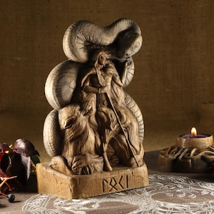 May include: A wooden carving of a Norse goddess riding a wolf, with a serpent wrapped around her. The carving is detailed and intricate, with a runic inscription at the base.