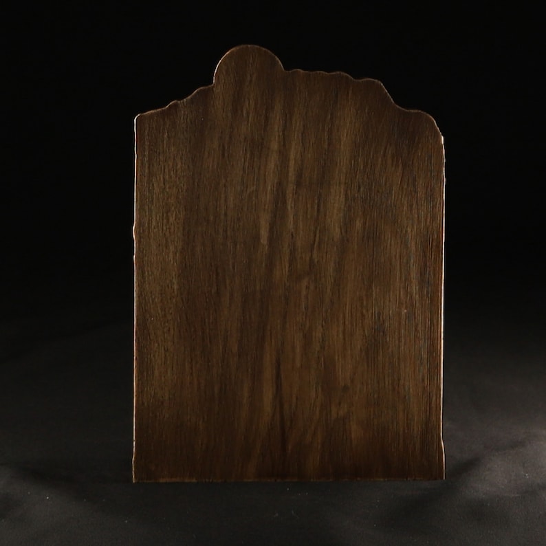 May include: A dark brown wooden sign with an irregular, wavy top edge. The sign is made of wood with a natural grain pattern.
