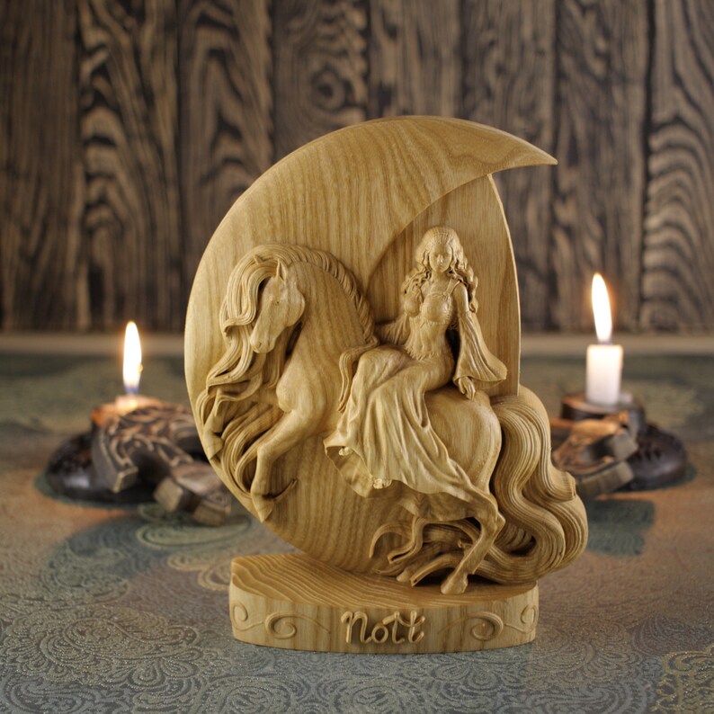 May include: A wooden carving of a woman riding a horse, with the word "Nott" carved below. The carving is on a crescent moon-shaped base.
