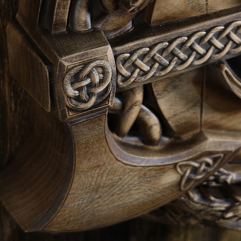 May include: A wooden wall decor featuring a carved anchor with intricate Celtic knot designs. The anchor is painted in a dark brown color and has a weathered finish.