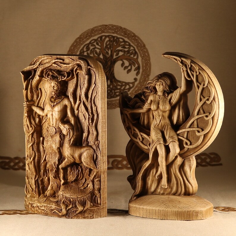 May include: Two wooden carvings, one depicting a figure standing in a forest and the other a figure standing in a crescent moon. Both carvings are detailed and intricate.