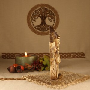May include: A wooden carving of a face with intricate details. The carving is on a wooden base and has a rustic, natural look.
