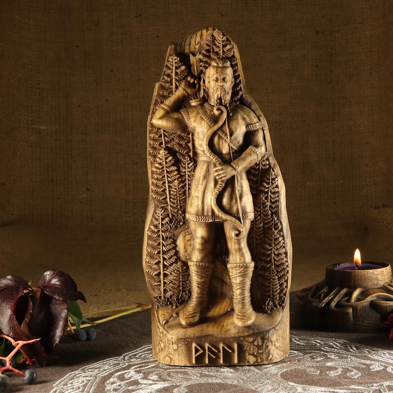 May include: Wooden carving of a Norse god holding a bow and arrow, standing in front of a fern background. The carving is on a wooden base with the word "PEFN" inscribed on it.