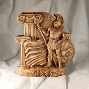 Handmade wooden Ares statue, Greek god of war wood carving with spear and shield standing near ancient Greek columns, pagan altar decor.