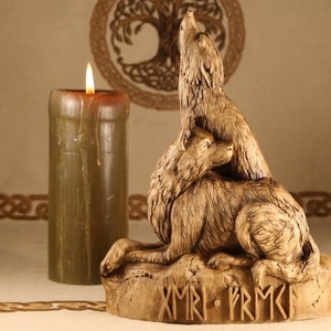 May include: A wooden sculpture of two wolves howling at the moon. The wolves are carved in a realistic style and are painted in a golden brown color. The sculpture is sitting on a wooden base with the inscription "XMRI - PRMK" carved into it.