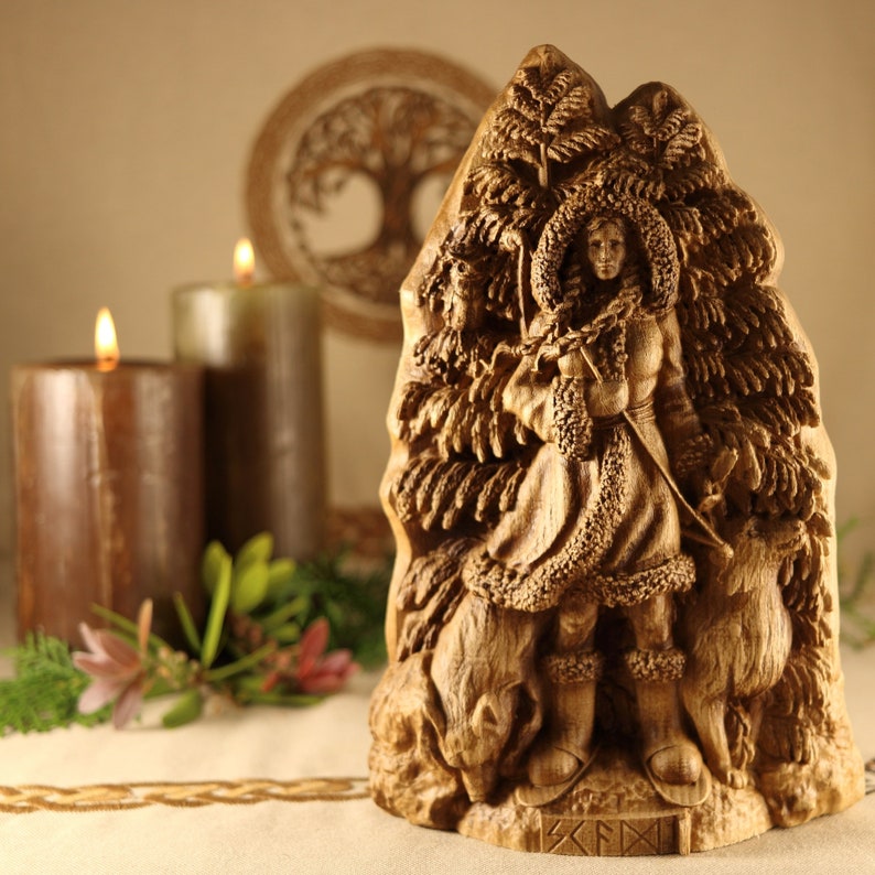 May include: A wooden carving of a woman standing in a forest, surrounded by trees and animals. The woman is wearing a long, flowing robe and a crown of leaves. The carving is detailed and intricate, with a warm brown color.