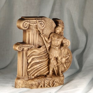 Side angle view of a wooden Ares statue, showcasing deep relief carving details, Corinthian columns, and warrior armor in perspective.