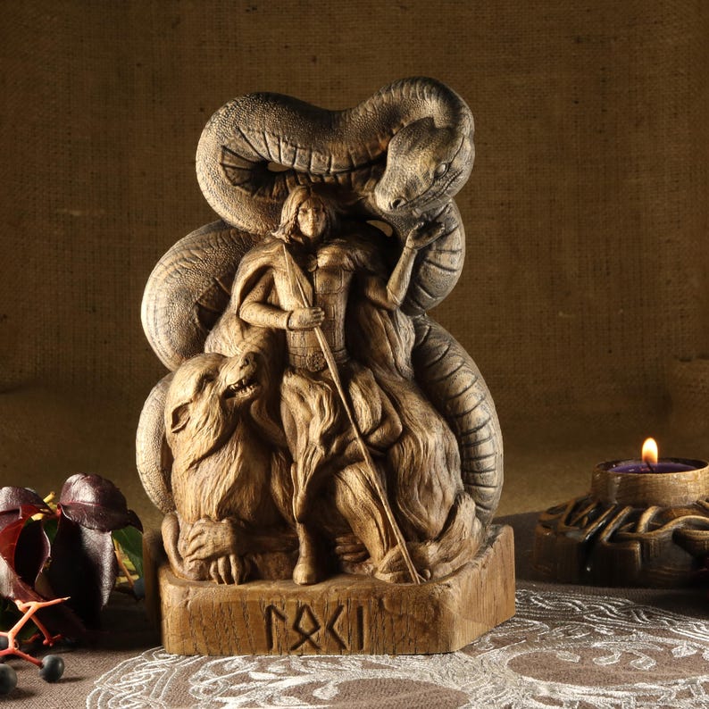 May include: Wooden sculpture of a female figure with a snake wrapped around her, a wolf at her feet, and the word "Fylgja" inscribed on the base.