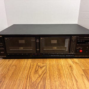 May include: A black Toshiba stereo cassette deck, model PC-G66WR, featuring dual cassette compartments, a peak level meter, and various control buttons. The front panel includes labels for record level, Dolby NR, and other audio playback functions.