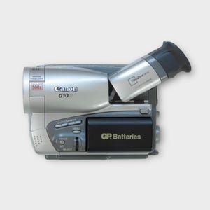 May include: Silver Canon G10 camcorder with a black FlexiZone viewfinder and a black battery compartment labeled "GP Batteries." Features include "500x" zoom and "Image Stabilizer."