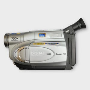 Könnte beinhalten: Silberne digitale JVC-Videokamera mit schwarzem Griff und Sucher. Merkmale sind 700x Digitalzoom, VHS-C-Kompatibilität und Bildstabilisator. Auf der Kamera steht "DIGITAL VHS Compact VHS".