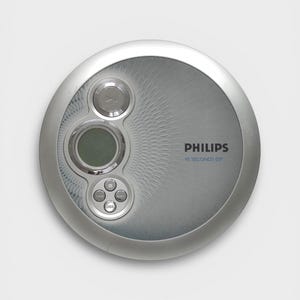 May include: A silver Philips portable CD player with a circular design. It features a play button, a small screen, and other control buttons. The text "PHILIPS" and "45 SECONDS ESP" are printed on the device.