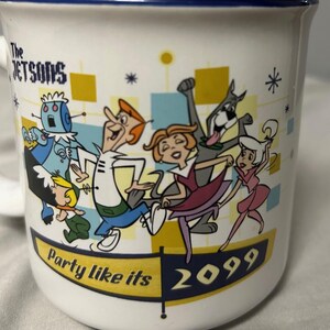 May include: White ceramic mug featuring a colorful illustration of The Jetsons cartoon characters. The mug has a blue rim and the text "Party like its 2099". The Jetsons characters are depicted in a retro style, with vibrant colors and dynamic poses.