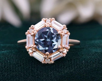 May include: A rose gold engagement ring with a large, round, blue gemstone surrounded by a halo of smaller, baguette-shaped diamonds.