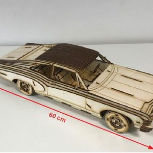 Pode incluir: Um kit de modelo de madeira de um carro clássico, medindo 60 cm de comprimento, 22 cm de largura e 15 cm de altura. O modelo é feito de madeira cortada a laser e apresenta detalhes intrincados.