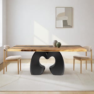May include: A rectangular dining table with a natural wood grain live edge top and a black sculptural base featuring two curved, interconnected supports. Two light beige upholstered chairs with wooden frames are positioned at the table.
