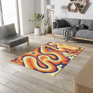 May include: A retro-style area rug with a swirling pattern in shades of orange, yellow, and blue. The rug is laid out on a wooden floor in a living room setting.