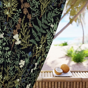 K&ouml;nnte beinhalten: Ein schwarzer Vorhang mit einem botanischen Druck aus Farnen, Bl&auml;ttern und Beeren. Der Vorhang ist teilweise ge&ouml;ffnet und gibt den Blick auf einen Strand mit Palmen und Kokosn&uuml;ssen frei.