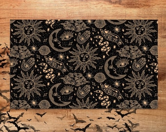 May include: A black background with a repeating pattern of gold celestial and mystical symbols. The pattern includes suns, moons, stars, hands, snakes, and clouds.