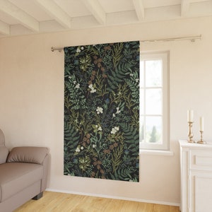 K&ouml;nnte beinhalten: Ein schwarzer Vorhang mit einem floralen Muster aus gr&uuml;nen Bl&auml;ttern, wei&szlig;en Bl&uuml;ten und braunen Zweigen. Der Vorhang h&auml;ngt in einem Raum mit einem Fenster und einer wei&szlig;en Wand.