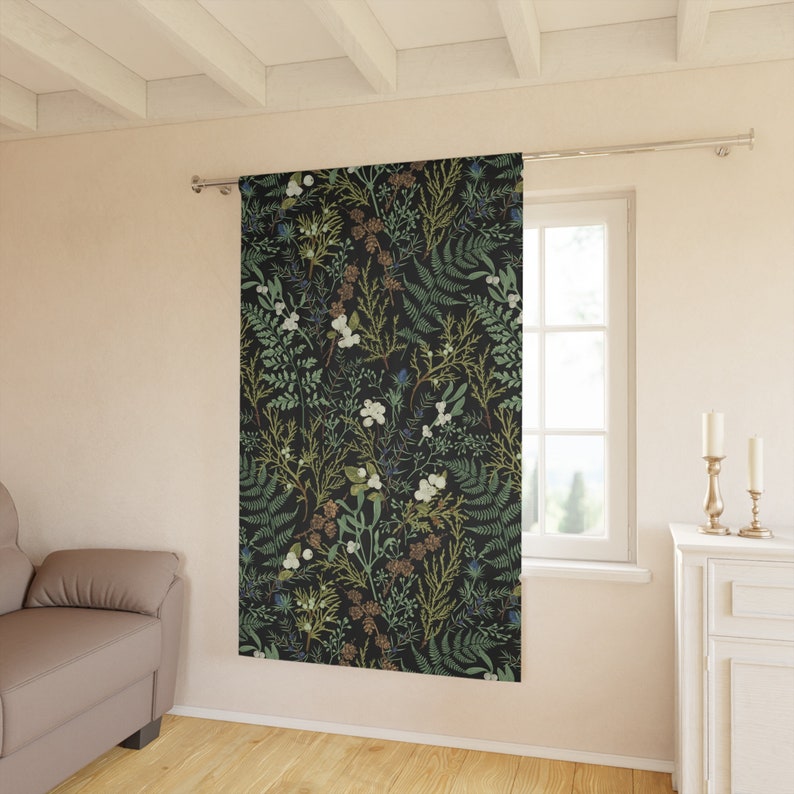 K&ouml;nnte beinhalten: Ein schwarzer Vorhang mit einem floralen Muster aus gr&uuml;nen Bl&auml;ttern, wei&szlig;en Bl&uuml;ten und braunen Zweigen. Der Vorhang h&auml;ngt in einem Raum mit einem Fenster und einer wei&szlig;en Wand.