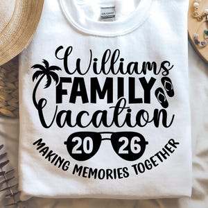 May include: White crew neck sweatshirt with the text "Williams FAMILY Vacation 2026 MAKING MEMORIES TOGETHER" in black. The design includes a palm tree, sunglasses, and flip-flops.